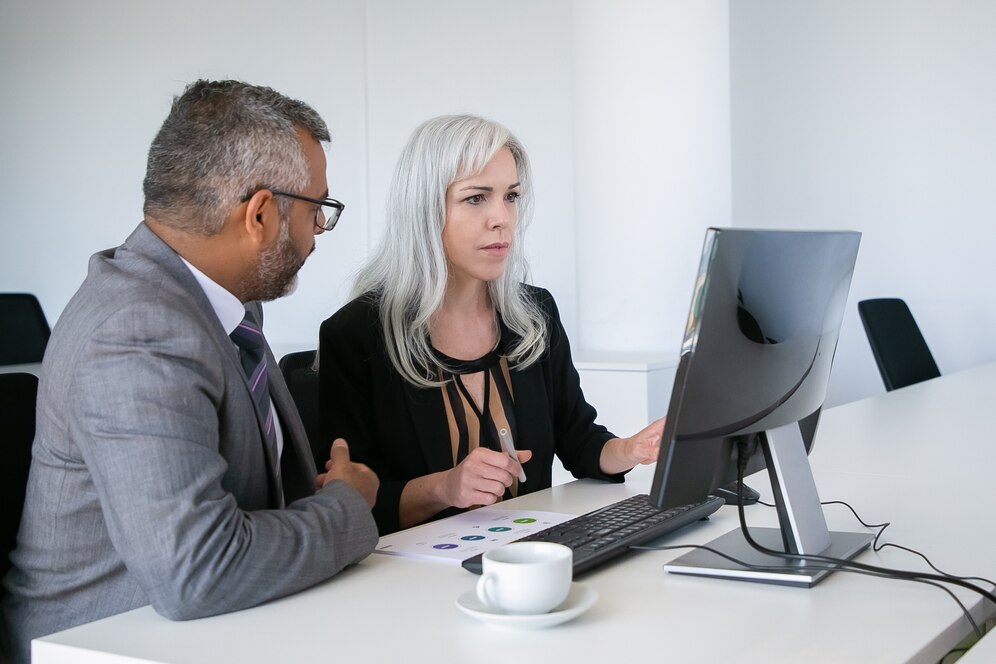 Business professionals using AI writing assistant in meeting